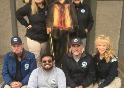 Group posing with a life-size statue outside the Old Lincoln County Courthouse.
