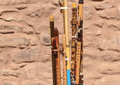 Colorful pencils standing upright in a wooden holder on a black table with a stone wall background.