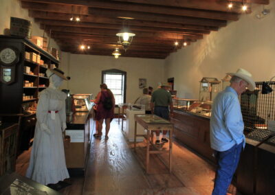 Historic antique shop interior with display cases and customers browsing.