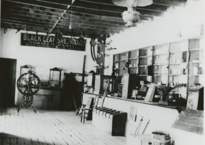 Vintage workshop interior with machines, shelves, and a long counter.