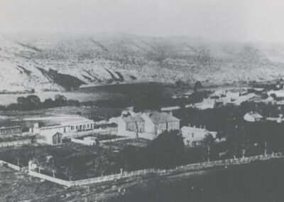 Old black-and-white hillside town with low buildings and terraced fields.