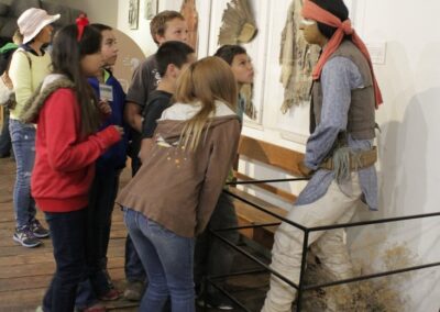 Group of children viewing museum exhibit panels with a guide.