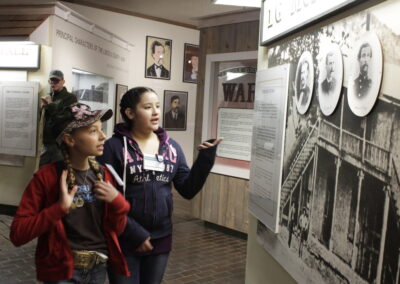 Two young people in a museum view war history exhibit panels.