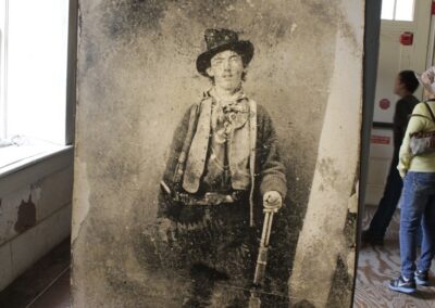 Vintage black-and-white photo of an elderly man in a hat holding a cane.