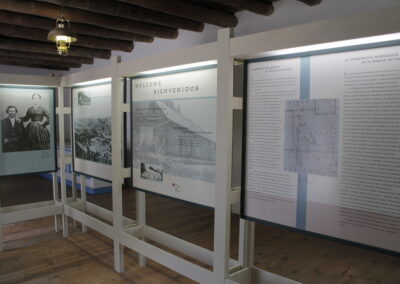 Indoor museum exhibition with framed photos and large text panels on display.