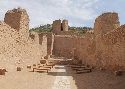 Desert ruin with sunlit adobe brick walls and a central stone stairway.