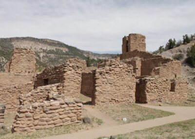 Ancient stone ruins with a hilltop tower and dirt path.