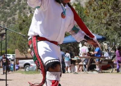 Native American dancer in traditional regalia performing outdoors.